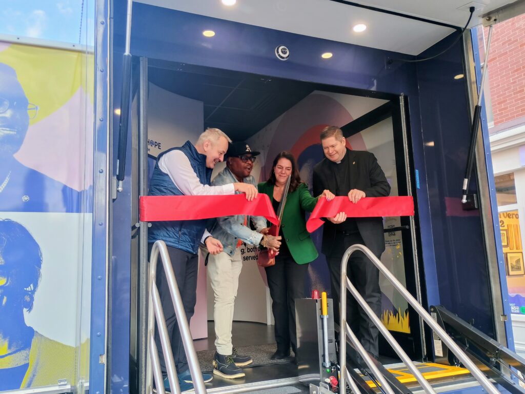 Jamar Carr, a substance abuse counselor with Catholic Charities, Diocese of Brooklyn, cuts the ceremonial ribbon during the launching of the three-year journey of Catholic Charities USA’s People of Hope Museum, Thursday, March 26, just north of Union Square, Manhattan. Photo by Armando Machado/The Good Newsroom