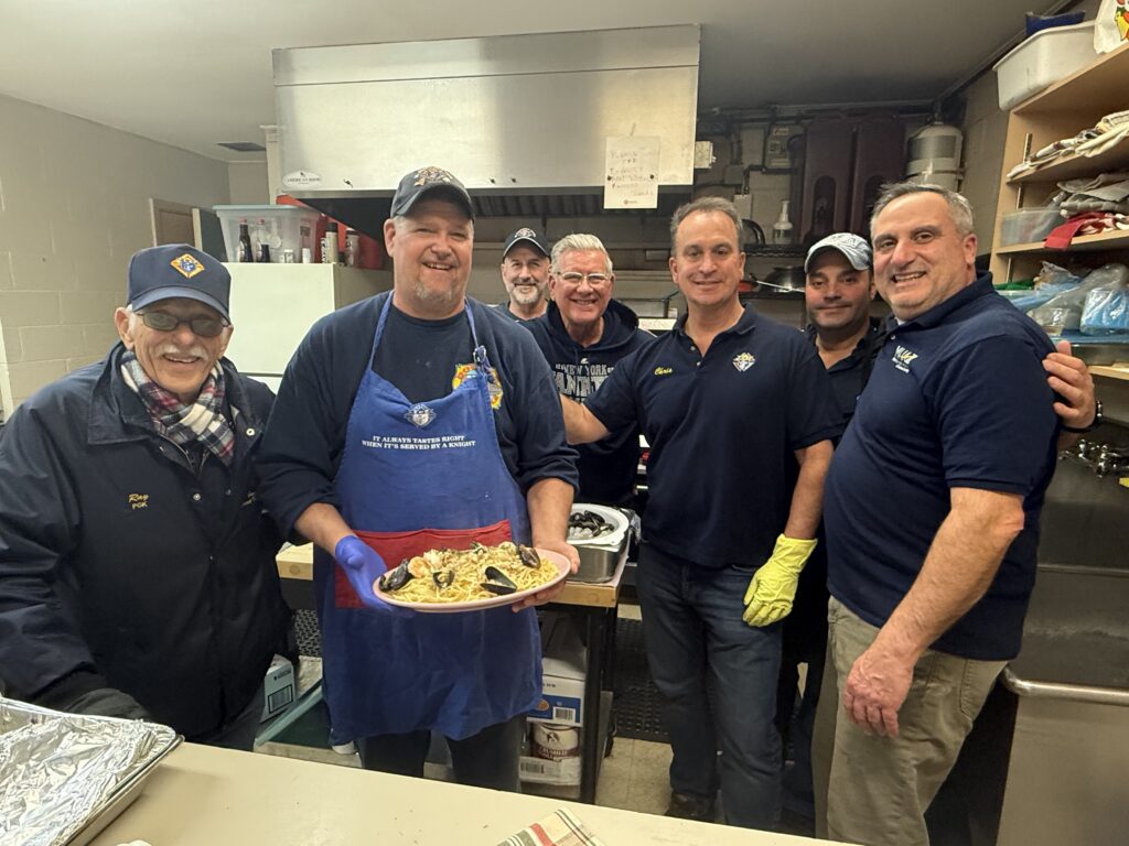 Grand Knight Bob Sandford (center, with platter) and members of Knights of Columbus Council 7875 serve up seafood at St. Stanislaus Kostka parish in Pleasant Valley, on Friday, March 13, 2026.