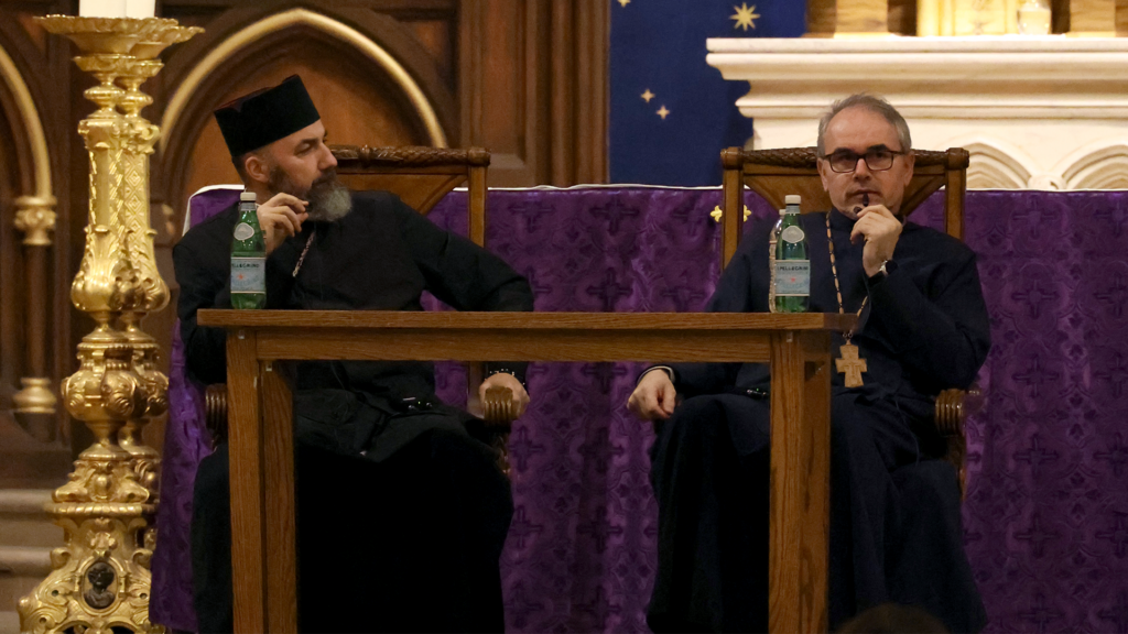 Metropolitan Archbishop Jonáš Maxim (left) being translated by Father Marek Visnovsky (right) on the altar of Old St. Patrick's Basilica.