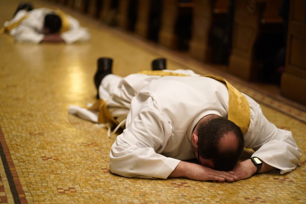Father Douglas Jones, then a deacon, lies prostrate during his ordination to the priesthood at St. Ignatius Loyola Church in New York City June 14, 2025. A new report from the Center for Applied Research in the Apostolate at Georgetown University, conducted for the U.S. bishops, looks at the defining features of the more than 400 men who will be ordained to the priesthood in 2026.