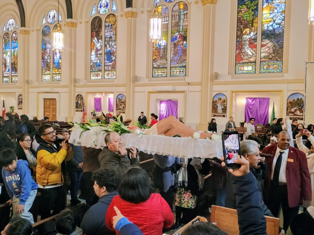 In the exit procession of the prayer service at St. Paul-Holy Rosary Parish, East 117th Street, Manhattan, several people carry a statue depicting Jesus after being taken down from the cross. The service was preceded by the annual East Harlem Good Friday Procession, April 3, 2026.