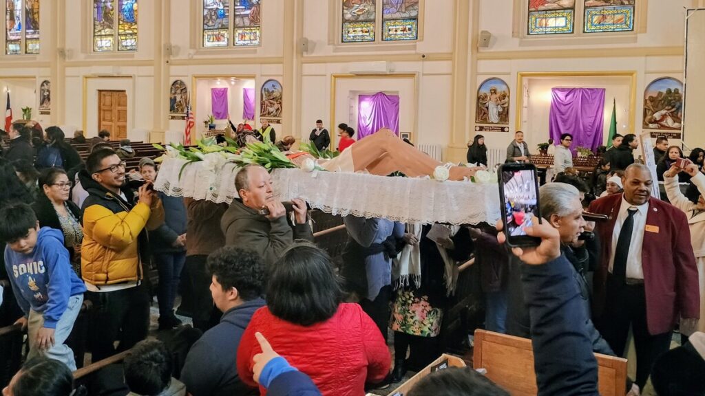 En la procesión de salida del servicio religioso celebrado en la parroquia de San Pablo y del Santo Rosario, situada en la calle 117 Este de Manhattan, varias personas portan una estatua que representa a Jesús tras ser bajado de la cruz. El servicio fue precedido por la procesión anual del Viernes Santo de East Harlem el 3 de abril de 2026. Foto: Armando Machado/The Good Newsroom