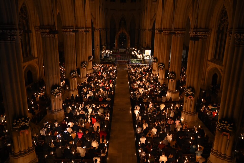 Attendees of the Easter Vigil the Holy Night of Easter Mass hold candles at Saint Patrick’s cathedral on April 4, 2026.