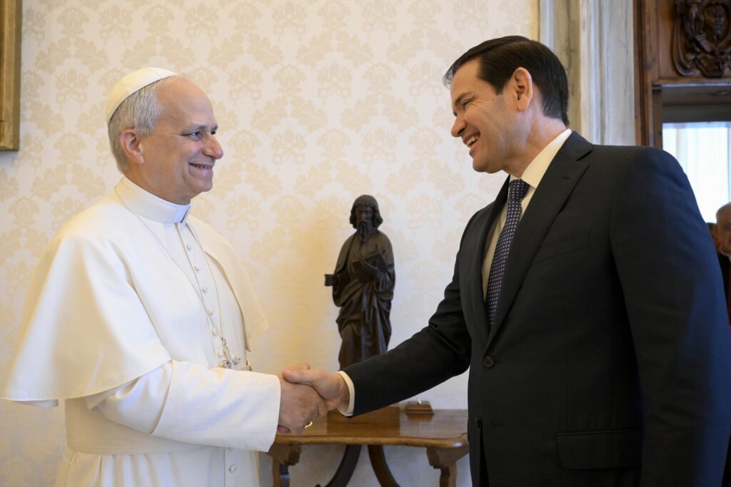 Pope Leo XIV shakes hands with Secretary of State Marco Rubio in the library of the Apostolic Palace at the Vatican May 19, 2025.