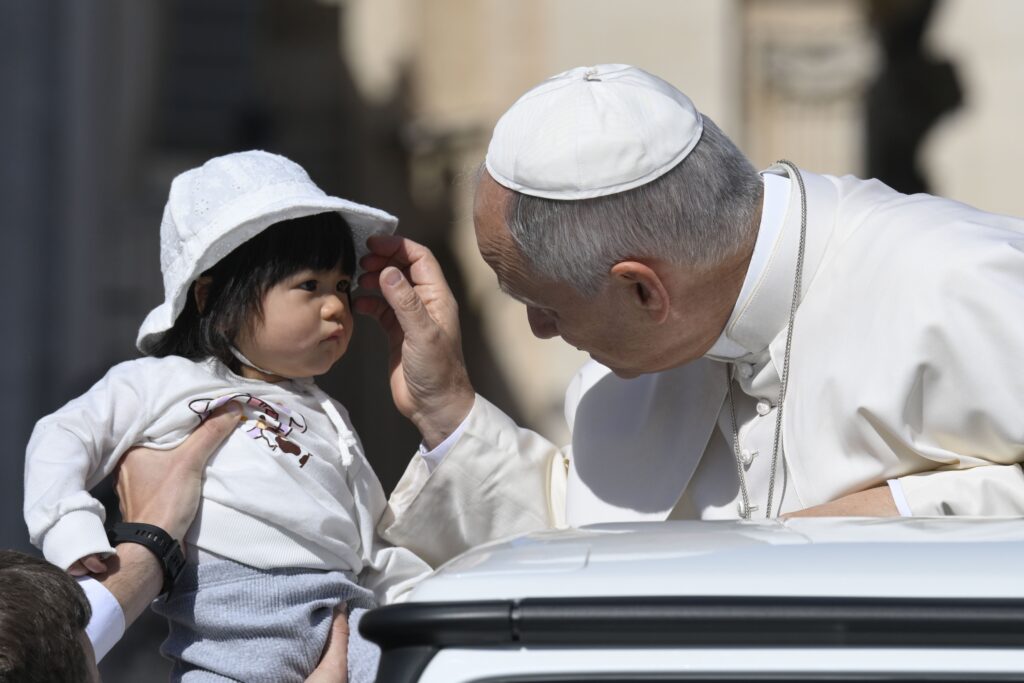 Pope Leo XIV blesses a baby as he rides in the popemobile before the start of this weekly general audience in St. Peter's Square at the Vatican, April 29, 2026.