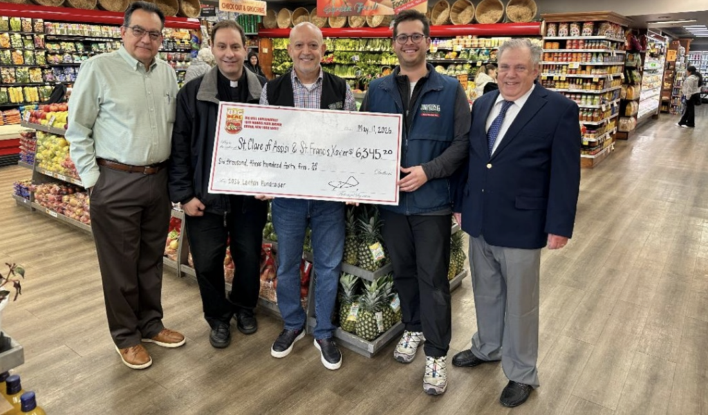 Big Deal Supermarket owner Miguel Garcia (center) presents a $6,345.20 check from this year's Lenten Fundraiser to Father Salvatore DeStefano (second from left), pastor of the Parish of St. Clare of Assisi/St. Francis Xavier and spiritual director of the AJM-Holy Name Society, at Big Deal Supermarket's gourmet produce section in Morris Park.