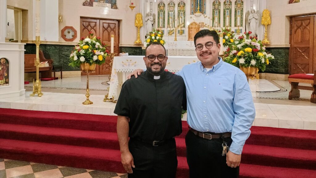 El padre Osvaldo Hernández y Kevin Serrano López cerca del santuario en la Iglesia Nuestra Señora de las Mercedes en el Bronx, el 12 de mayo de 2026. Foto por Armando Machado/The Good Newsroom