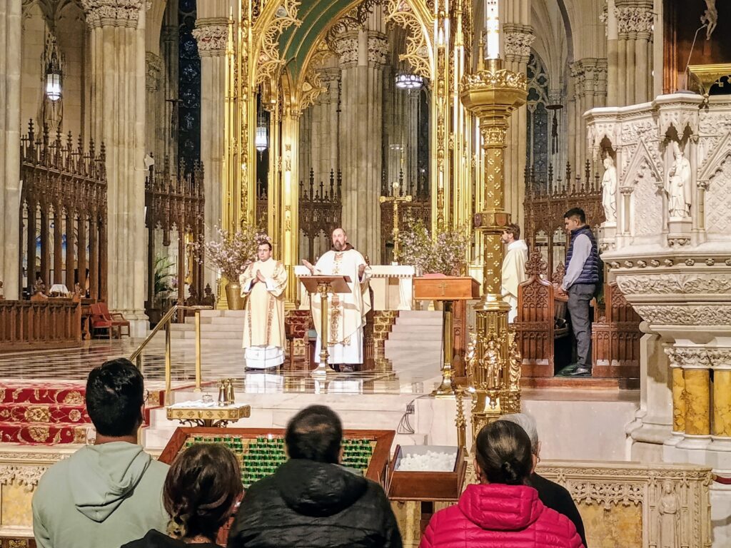 Father Erik Lenhart during the early moments of the monthly Young Adult Mass at St. Patrick’s Cathedral, Wednesday, May 6, 2026. Deacon Joseph Haas, who will be ordained at the cathedral on May 23, is to his left.