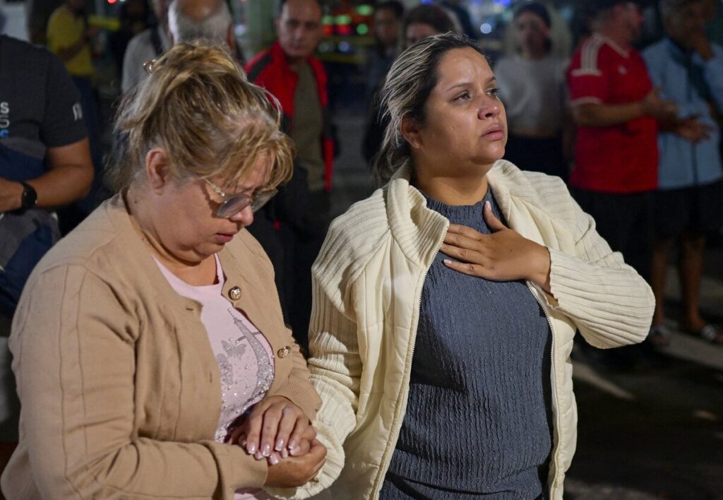 Astrid Espinoza y Noemí Córdoba, madre y abuela de Shantal Quintero, de 18 años, esperan en el lugar donde se ha derrumbado un edificio mientras los equipos de emergencia la buscan, en Caracas (Venezuela), el 24 de junio de 2026, tras los terremotos de magnitud 7.2 y 7.5 que sacudieron el país. (Foto de OSV News/Gaby Oraa, Reuters)