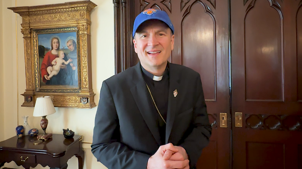 Archbishop Ronald A. Hicks of New York sports a Knicks cap as he discusses his friendly wager with Archbishop Gustavo García-Siller of San Antonio over the NBA Finals, which begin June 3.