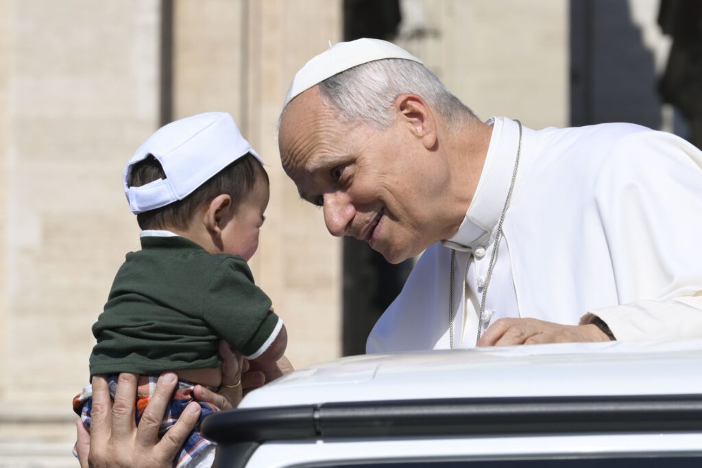 Pope Leo XIV greets a child from the popemobile while riding around St. Peter’s Square at the Vatican before his weekly general audience June 24, 2026.