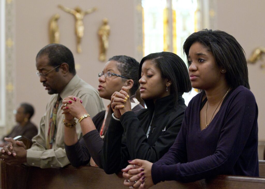 A family is pictured in a file photo praying before Mass.