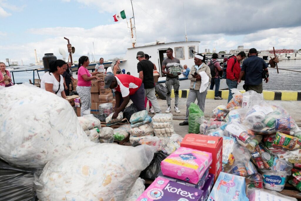 Miembros de una flotilla que partió de México, junto con trabajadores portuarios locales, descargan ayuda humanitaria a su llegada a la bahía de La Habana el 24 de marzo de 2026. Catholic Relief Services, la agencia humanitaria y de desarrollo de los obispos católicos de EE. UU., ha recibido 60 millones de dólares del Departamento de Estado de EE. UU. para ampliar la ayuda humanitaria a las familias vulnerables de toda Cuba. (Foto de OSV News: Jorge Luis Baños, vía Reuters)
