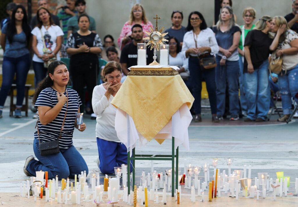 Un grupo de mujeres reza ante una custodia que contiene el Santísimo Sacramento a las puertas de la iglesia del Santuario de Nuestra Señora de los Dolores, en Valencia (Venezuela), el 28 de junio de 2026, durante una jornada nacional de oración por las víctimas de los terremotos de magnitud 7,2 y 7,5 que sacudieron el país el 24 de junio. (OSV News / Carlos Hernández, Reuters)