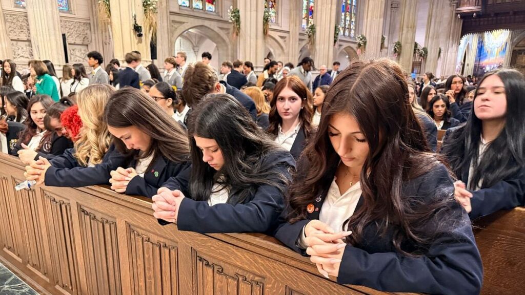 Estudiantes arrodillados durante la Misa para alumnos de último curso de secundaria en la Catedral de San Patricio en 2026. Foto de Mary Shovlain/The Good Newsroom.