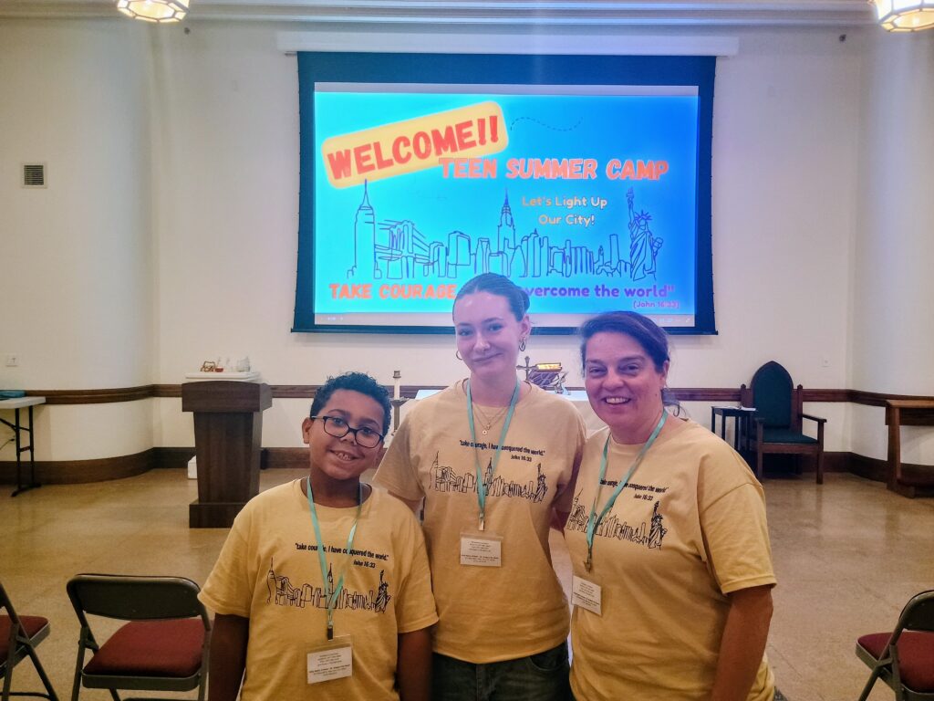 Ana Paula Panzarini, director of Evangelization and Faith Formation at Holy Name of Jesus/St. Gregory the Great parish (Manhattan), stands with Sterling Luna, 10, and Johanna S. Rueddel, 16, during the Teen Retreat summer day camp at the parish, Thursday, July 30, 2026.