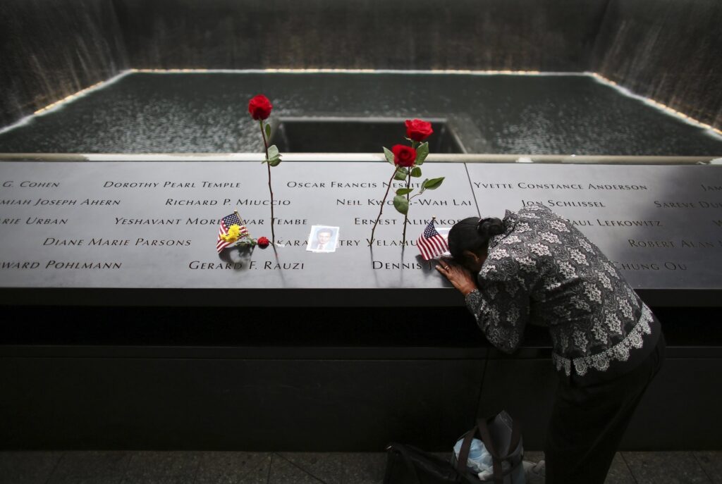 A woman grieves at the inscription of her late husband's name at the national 9/11 Memorial and Museum in New York City Sept. 11, 2014. Twenty-five years after the 9/11 terrorism attacks that claimed the lives of nearly 3,000 people, Catholic family members who lost loved ones that day have credited their faith with getting through the losses. Photo: OSV News photo/Chang Lee, Reuters