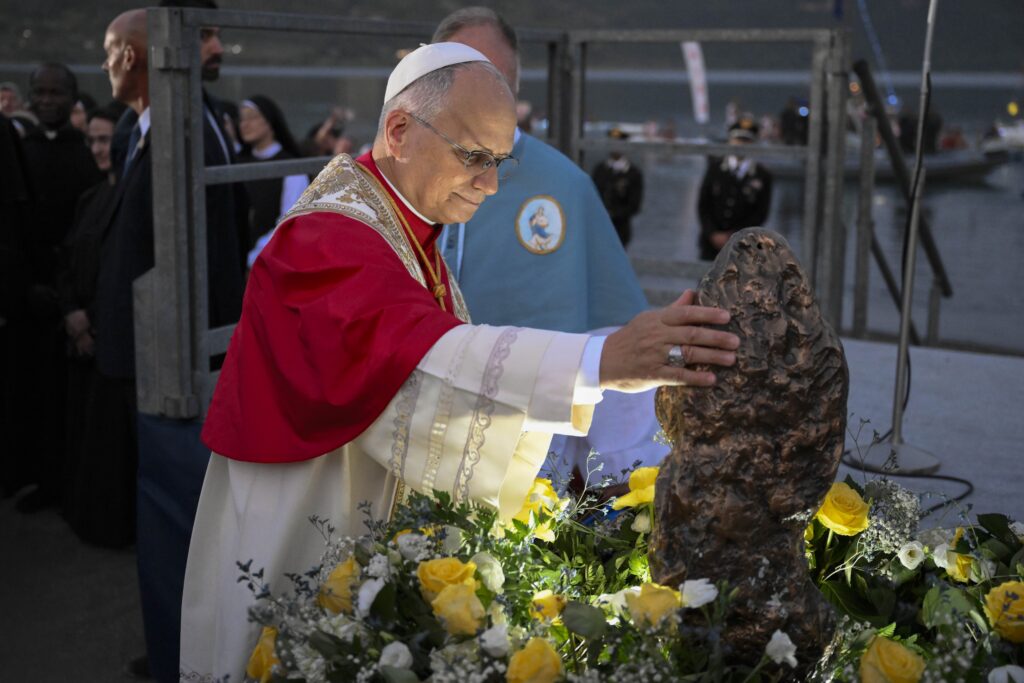 Pope Leo XIV touches a statue of Our Lady after taking part in a Marian procession along Lake Albano in Castel Gandolfo, Italy, Aug. 29, the feast of Our Lady of the Lake.
