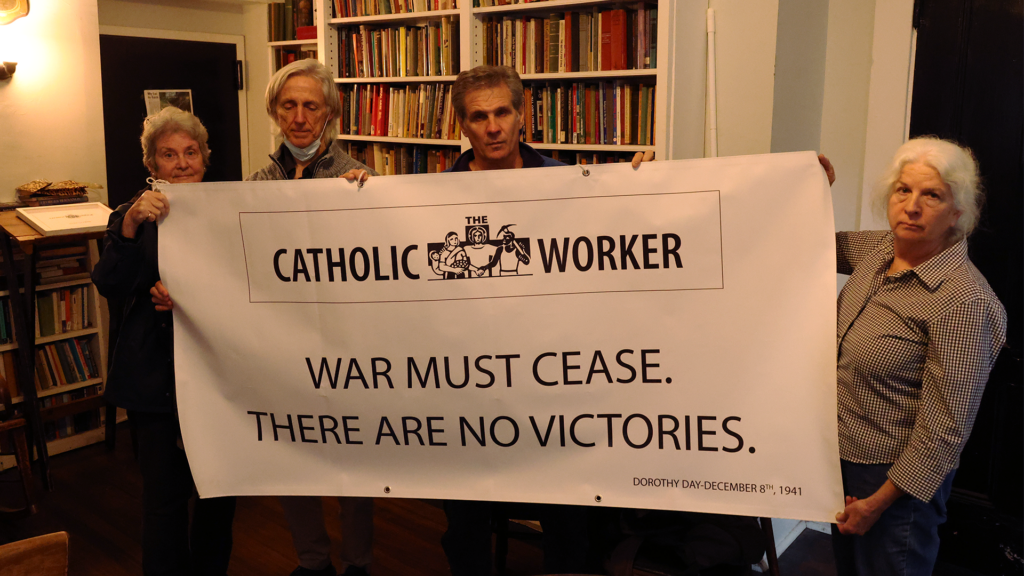Members of the Catholic Worker Movement hold a banner used at a vigil outside of St. Patrick's Cathedral calling for peace bearing with a quote from Dorothy Day: "War must cease. There are no victories." Pictured left to right: Cathy Breen, Bernard Connaughton, Carmen Trotta, Martha Hennessy.