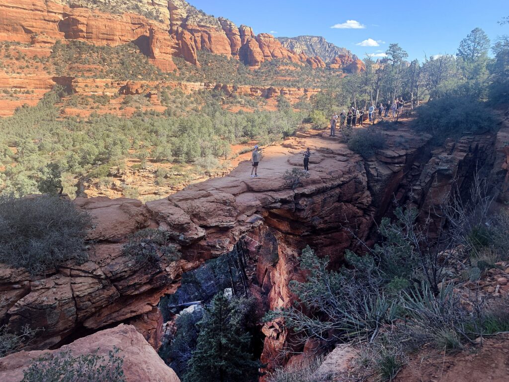 Hikers wait in line to have their pictures taken on Devil's Bridge in Sedona, Ariz., Feb. 7, 2026. Devil's Bridge is the largest natural sandstone arch in the area, offering a moderate 1.8 to 4.6-mile roundtrip hike, popular for its stunning, walkable, 54-foot-high, 100-foot-drop, bridge-like structure.