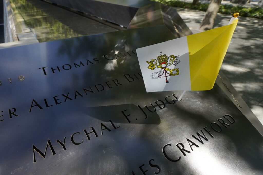 A Vatican flag is seen near the inscription of Franciscan Father Mychal Judge's name at the South Pool of the 9/11 Memorial in New York City Sept. 8, 2025. Father Judge, a chaplain with the New York Fire Department, was killed while ministering at the World Trade Center during the Sept. 11, 2001, terror attacks. The 25th anniversary of the attacks will be observed in 2026. Photo: OSV News photo/Gregory A. Shemitz