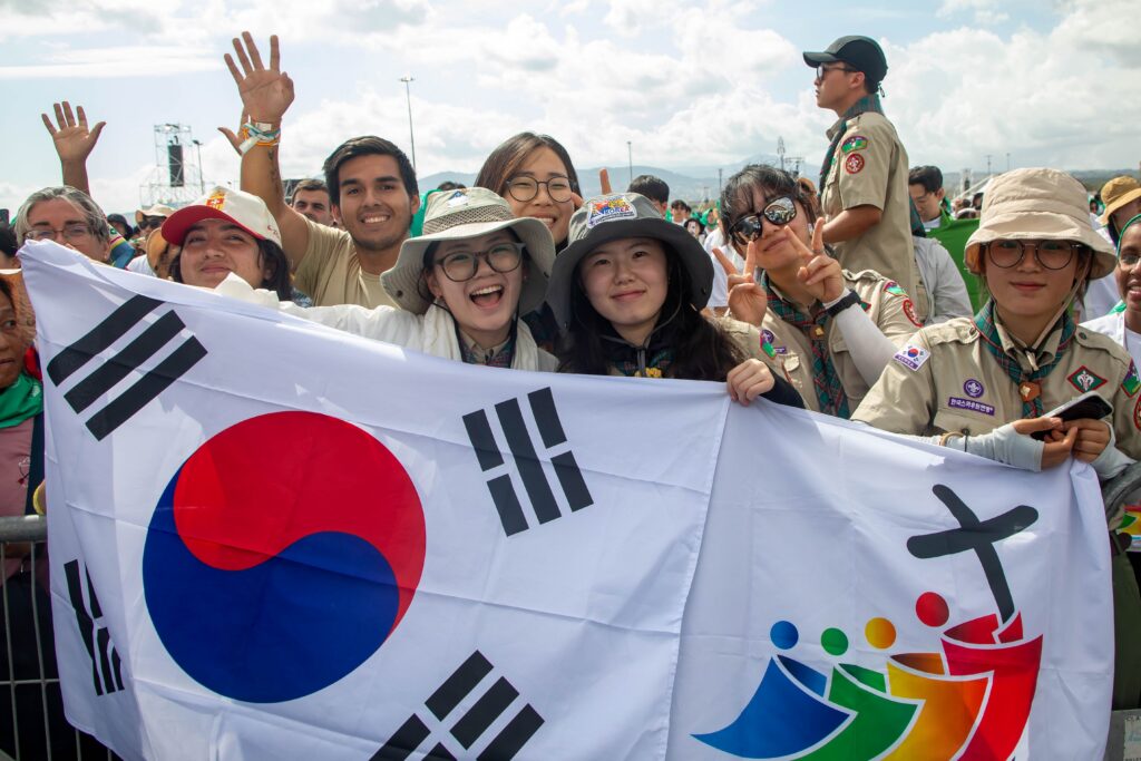 Pilgrims from South Korea wave flags and cheer as they participate in a Mass closing the Jubilee of Youth in Rome's Tor Vergata neighborhood on Aug. 3, 2025.