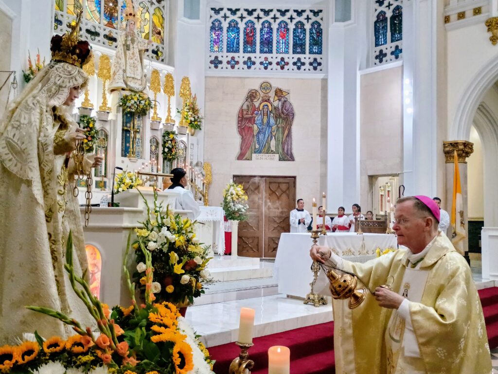Auxiliary Bishop Edmund Whalen blesses a figure of Our Lady of Mercy during the Sunday, Sept. 20 Mass at Our Lady of Mercy Church in the Bronx.