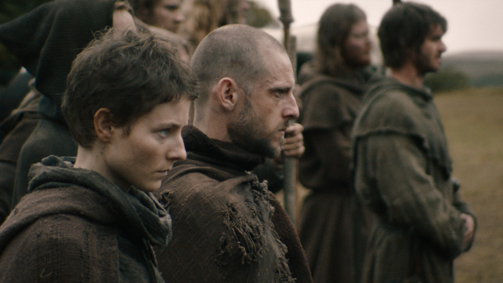 (L to R) Thomasin McKenzie as "Alyce," Jamie Bell as "John Ball," and Andrew Garfield as "Ploughman" in director Paul Greengrass's "The Uprising," a Focus Features Release.
