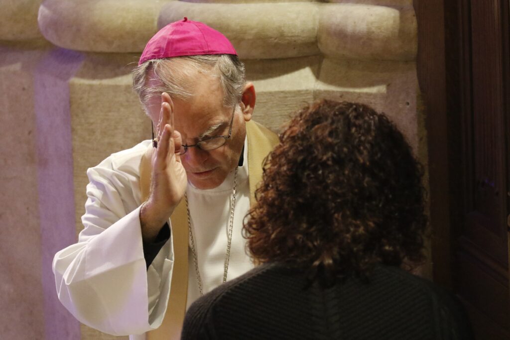 Auxiliary Bishop Peter J. Byrne of New York blesses a woman after hearing her confession Dec. 9 at St. Patrick's Cathedral in New York City. The Archdiocese of New York's Young Adult Outreach office sponsored an evening that included eucharistic adoration, confession and a Mass celebrated by New York Cardinal Timothy M. Dolan. More than 2,000 people attended the event.