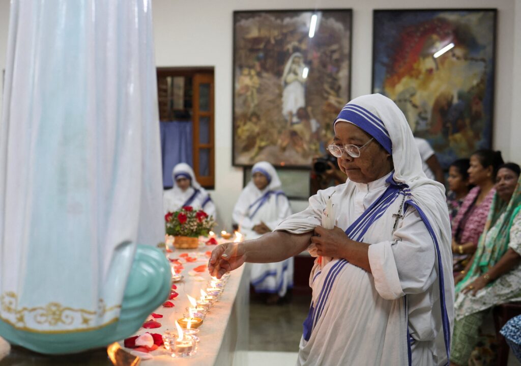 A member of the Missionaries of Charity lights a candle as people offer prayers at the tomb of St. Teresa of Kolkata in Kolkata, India, Aug. 6, 2026, to mark her 116th birth anniversary.