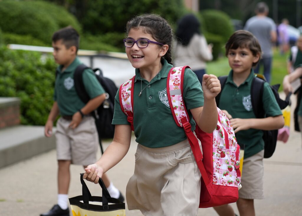 A student smiles as she arrives for the first day of the 2026-27 academic year at St. Patrick School in Smithtown, Sept. 3, 2026.