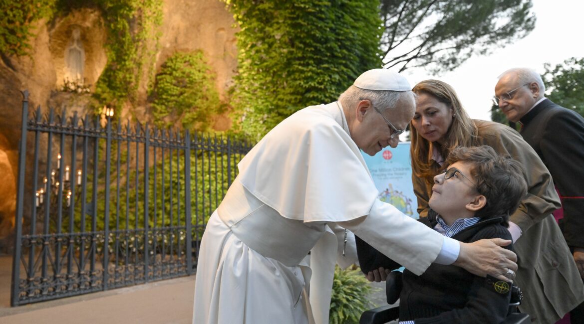 Pope Leo XIV greets a disabled child after joining hundreds of children in praying the rosary for peace at the Lourdes Grotto in the Vatican Gardens on the evening of Oct. 1, 2026, the month dedicated to the rosary.