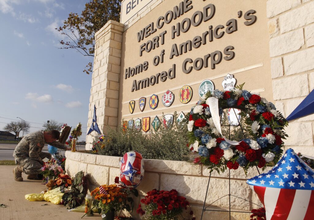 United States Army Specialist Robert Orcutt prays near a makeshift memorial for victims of the shootings at Fort Hood Army post in Fort Hood, Texas November 9, 2009. In an Oct. 8, 2026 interview, Secretary of Defense Pete Hegseth said they planned to livestream the execution of Fort Hood shooter Nidal Malik Hasan by firing squad in December; Archbishop Paul S. Coakley, president of the U.S. Conference of Catholic Bishops, denounced the plan as "barbaric” in an Oct. 9 statement.