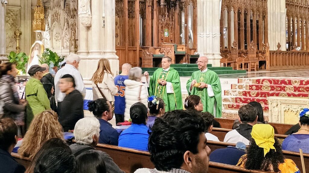 El padre Enrique Salvo (a la izquierda), rector de la Catedral de San Patricio, y el padre Zach Presutti, SJ, reparten la comunión durante la Misa de la Herencia Hispana en la catedral el domingo 4 de octubre de 2026. Foto de Armando Machado/The Good Newsroom