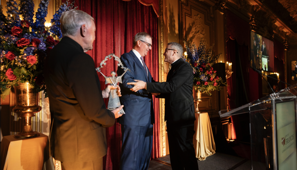 Brendan Mulshine, center, receives the Catholic Extension Society's 2026 Spirit of Francis Award from Archbishop Ronald Hicks. Fr. Jack Wall, president of Catholic Extension Society, is at left.