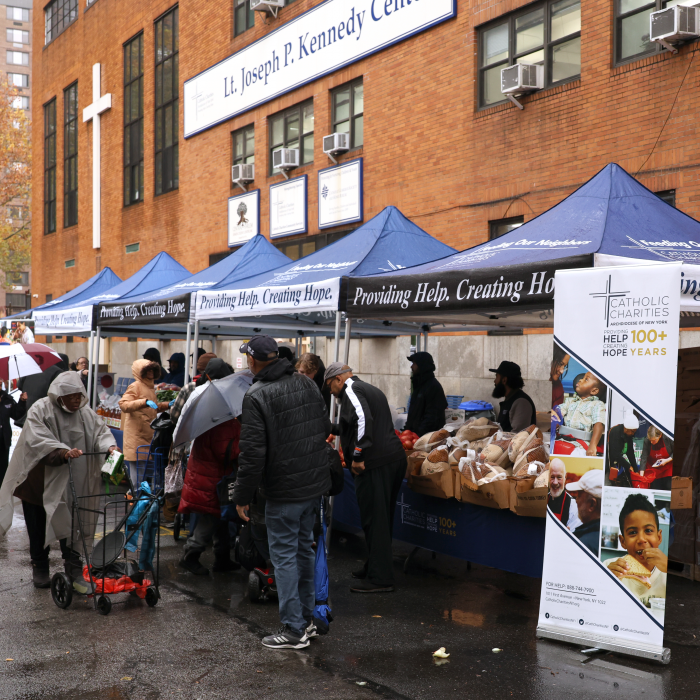 Catholic Charities sets up tents in the rain as clients come through to receive a full Thanksgiving meal in groceries.