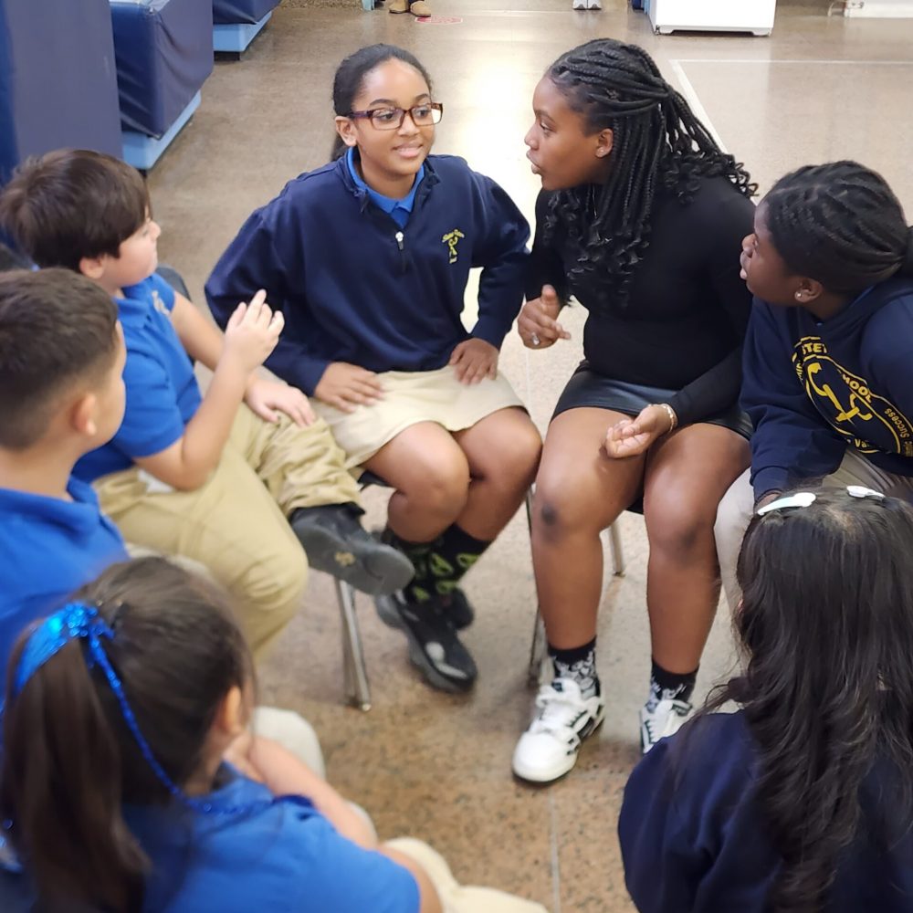 Students discuss with their group to plan their next move.