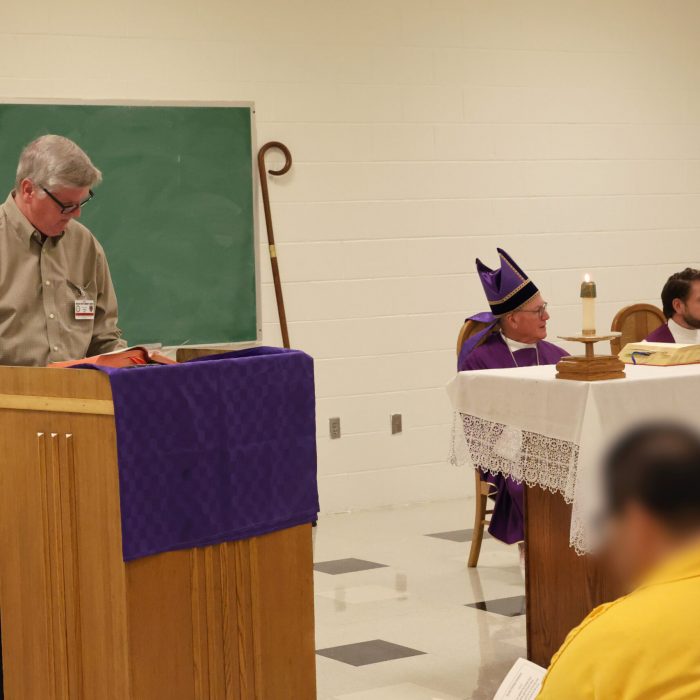 One of the prison volunteers reads from the Bible to the congregation.