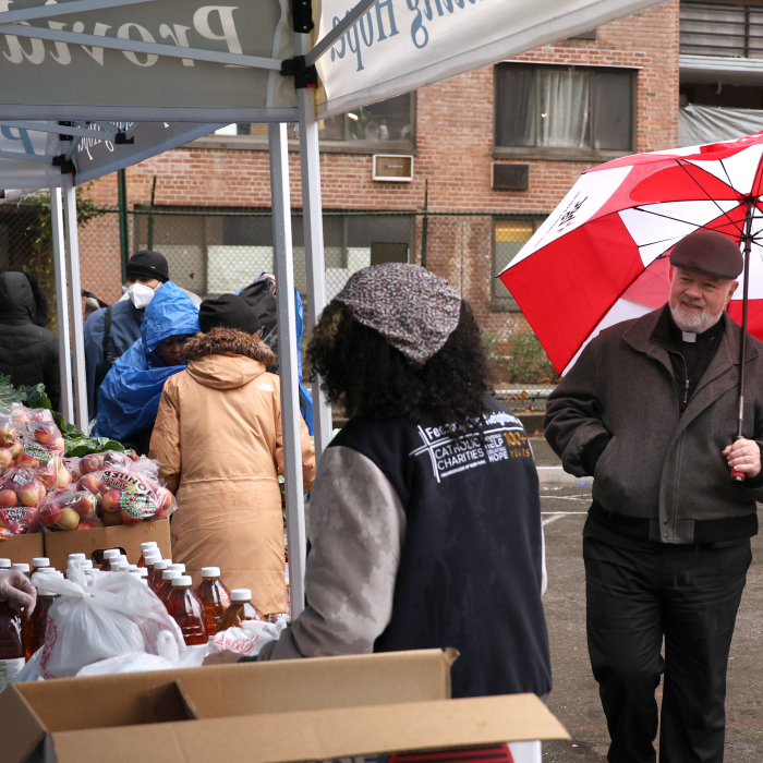 Msgr. Sullivan visits the volunteers to see how the distribution effort is going despite the unfortunate weather conditions.