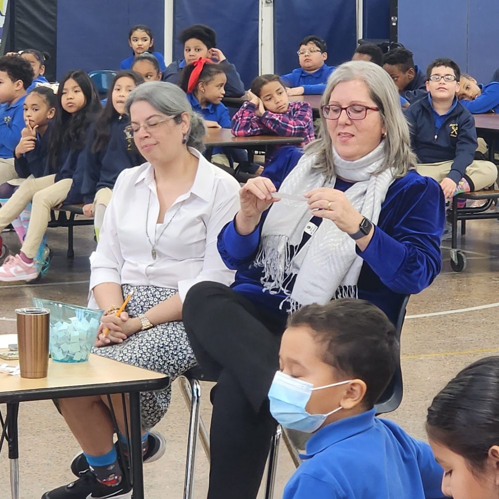 The hosts, Mrs. Sheila Alagia and Mrs. Ana Germosen, read the question aloud for the students to answer.