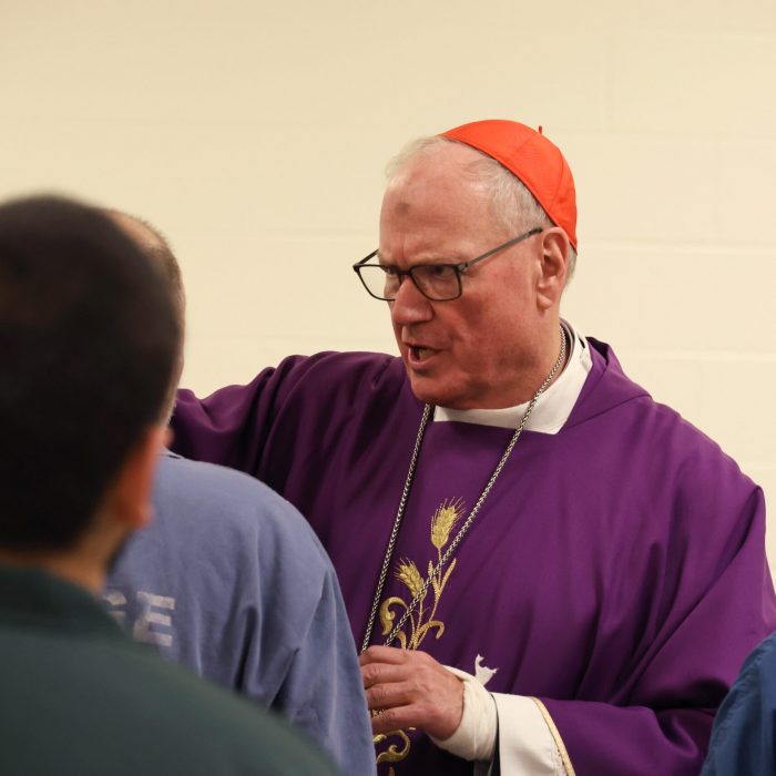 Cardinal Dolan gives out ashes to the incarcerated.