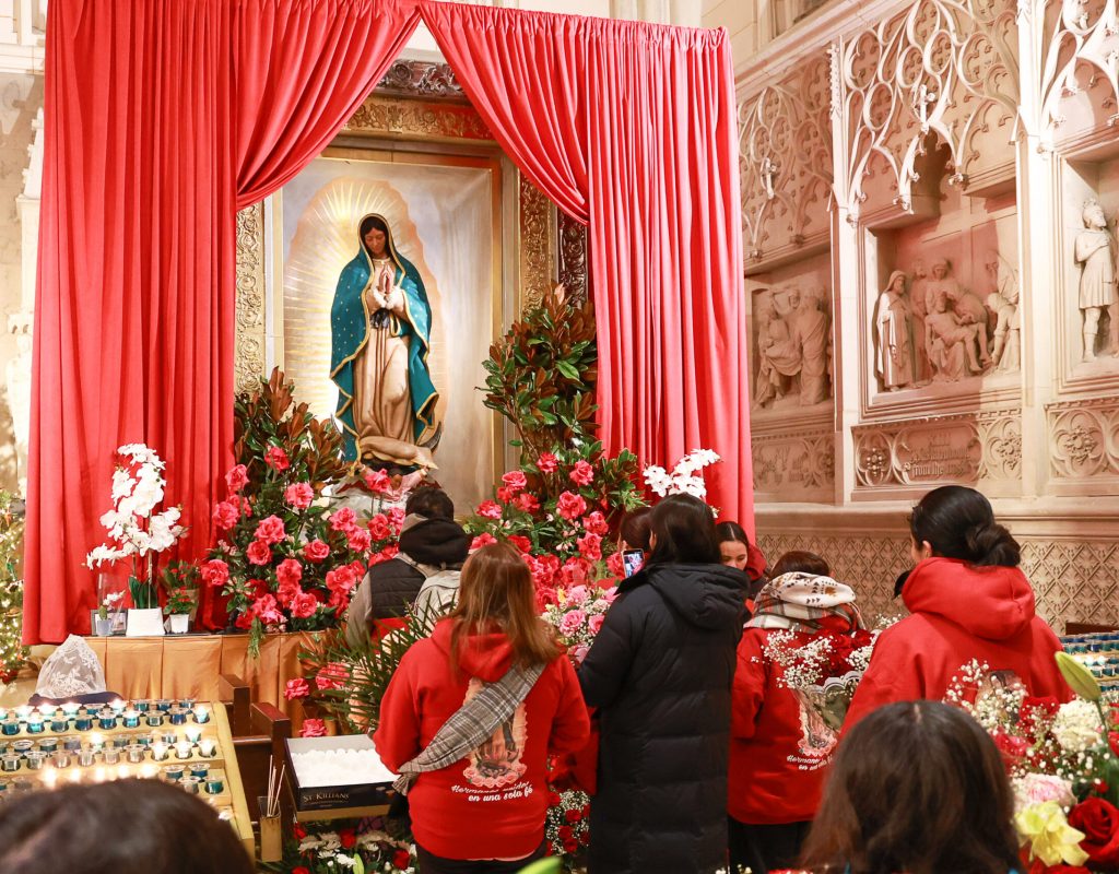 Pilgrims present flowers to the sculpture of the Madre Peregrina (Pilgrim Mother), accompanied by a faithful replica of the original tilma of Our Lady of Guadalupe. The sculpture is currently at Saint Patrick’s Cathedral as part of its international tour that began in 2006. Photo by Joe Vericker/Photobureau