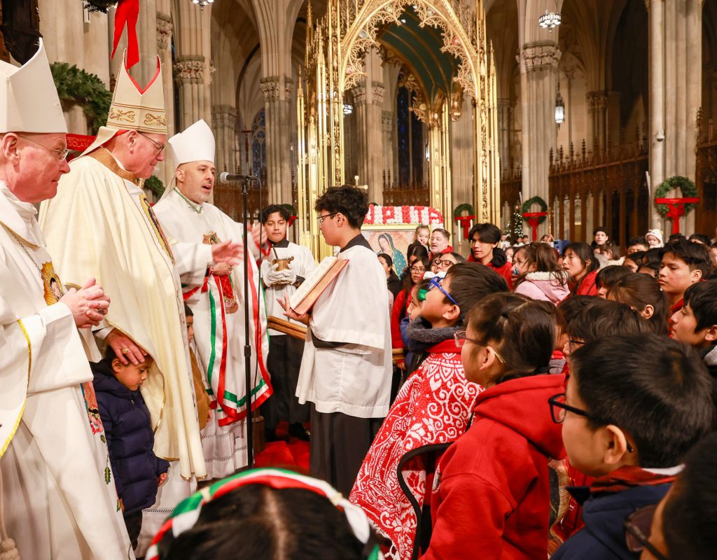 Archdiocese of New York Auxiliary Bishop Edmund J. Whalen (left), Cardinal Timothy Dolan (center left) and Auxiliary Bishop Joseph Espaillat (at microphone) offer a blessing hundreds of young pilgrims who participated in the Our Lady of Guadalupe procession and then Mass on the Our Lady’s feast day, December 12, 2025, at St. Patrick’s Cathedral.